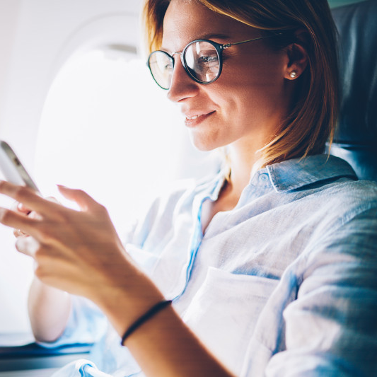 Person using a smartphone on an airplane.