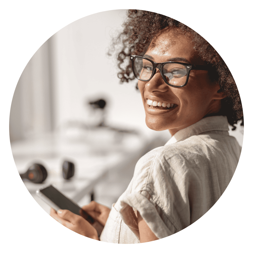 Femme souriante avec un téléphone mobile à la main