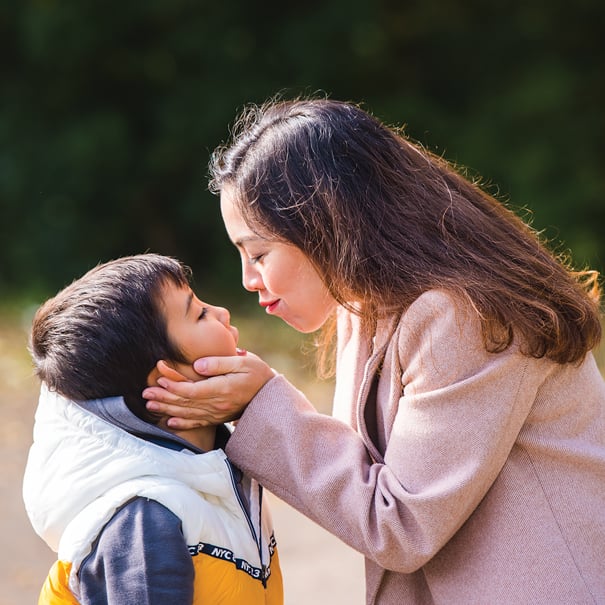 A mum is kissing her son