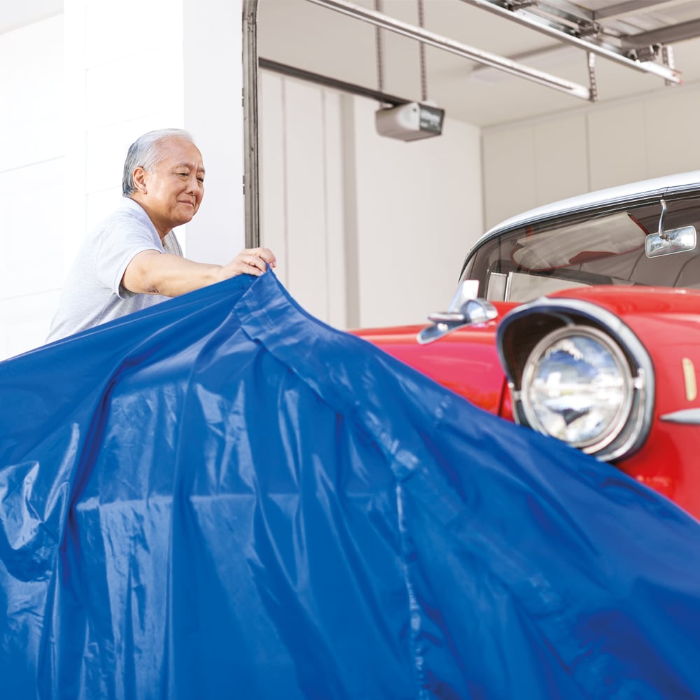 a man is covering a car