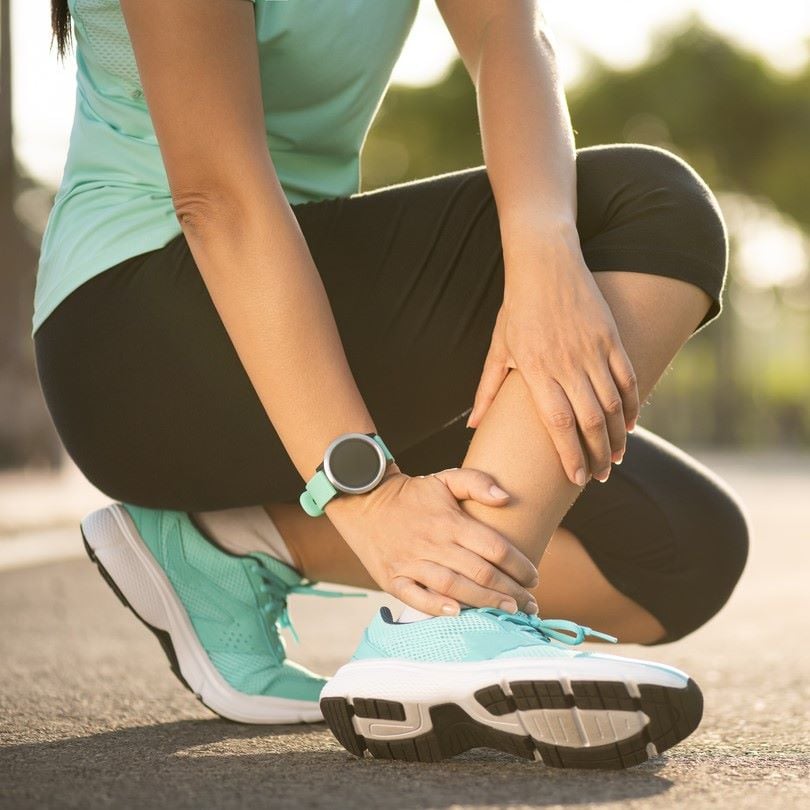 sprained ankle woman on pavement