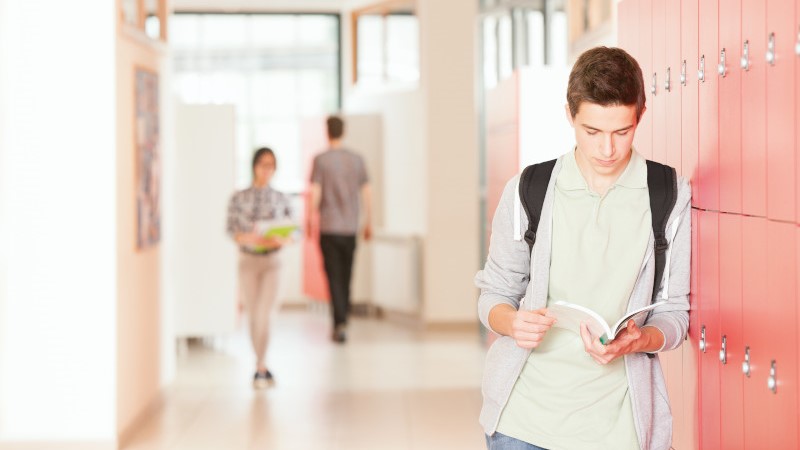 A student studying at a corridor in a university