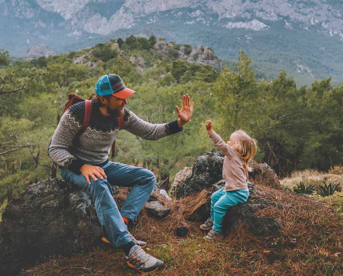 Father and child high five hands traveling in mountains hiking together