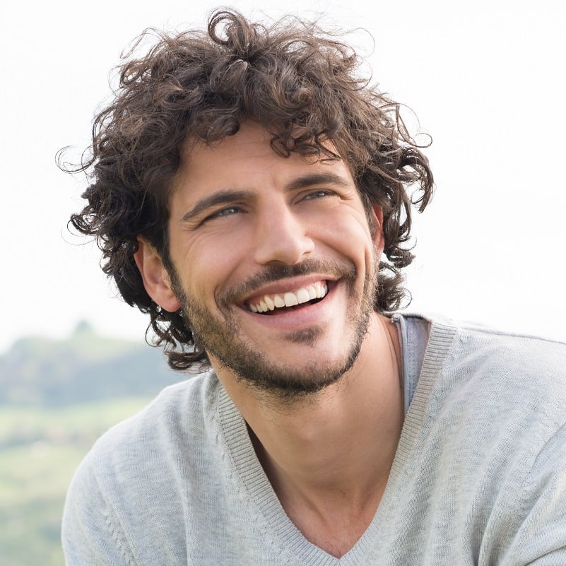 Man with curly hair smiling