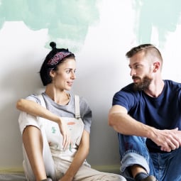 Young couple painting the wall