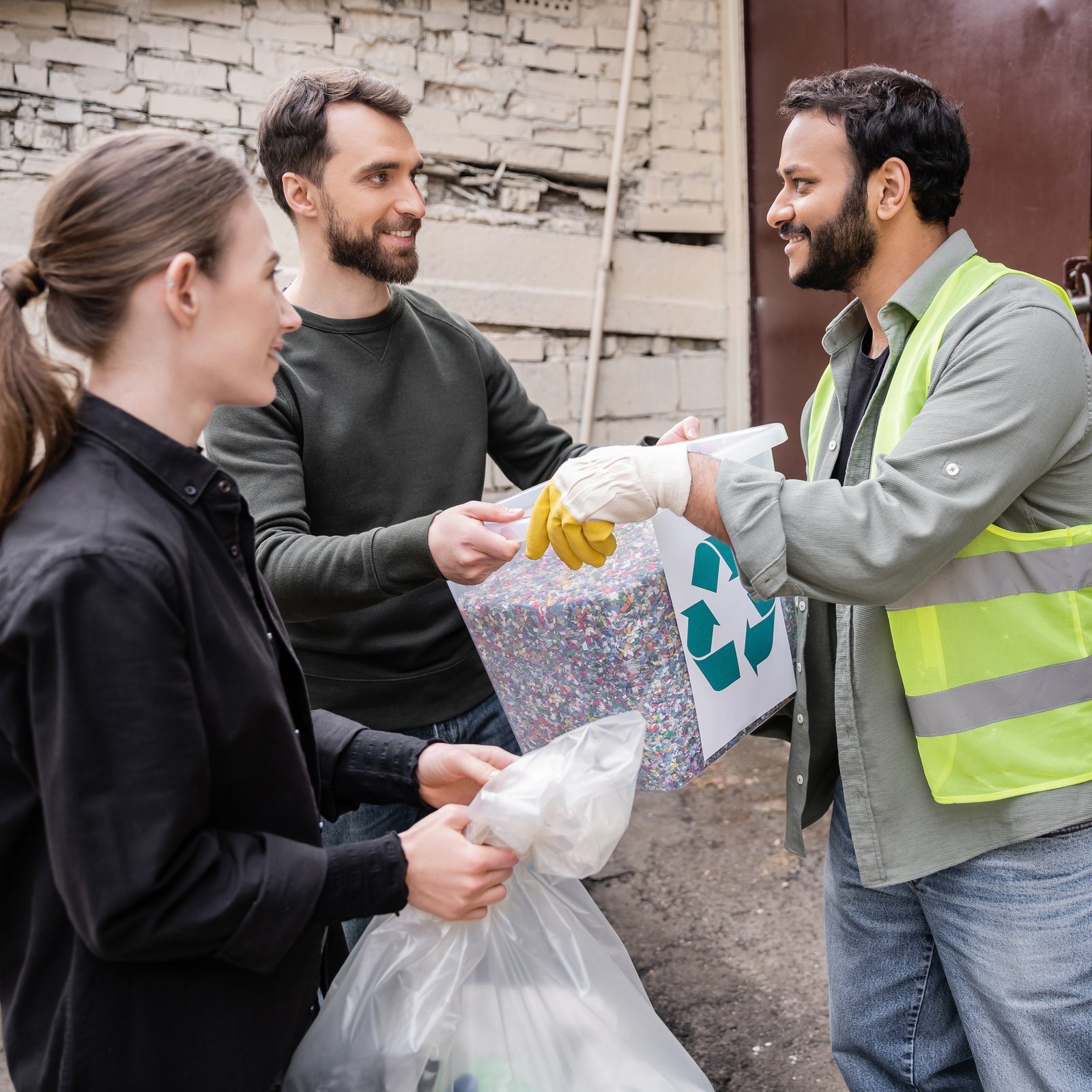 smiling-volunteer-giving-trash-bin-with-recycle