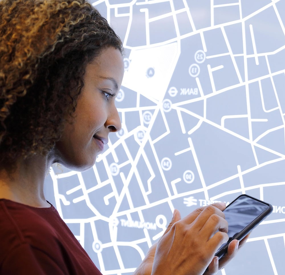 woman in front of digital map looking right