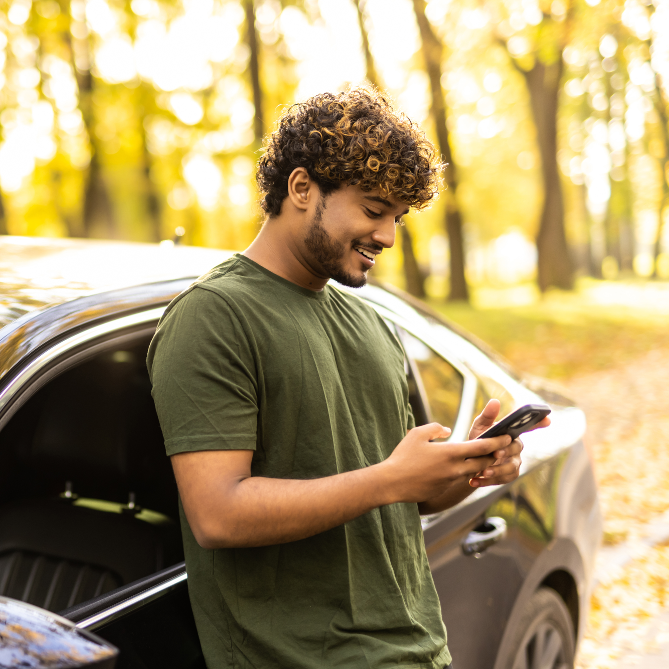 Homem junto a um carro com telemovel na mão