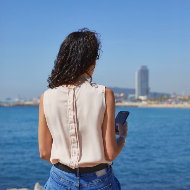 Woman sitting in front of beach in Barcelona