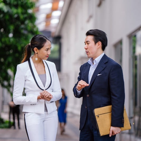 Business professionals talking in hallway.