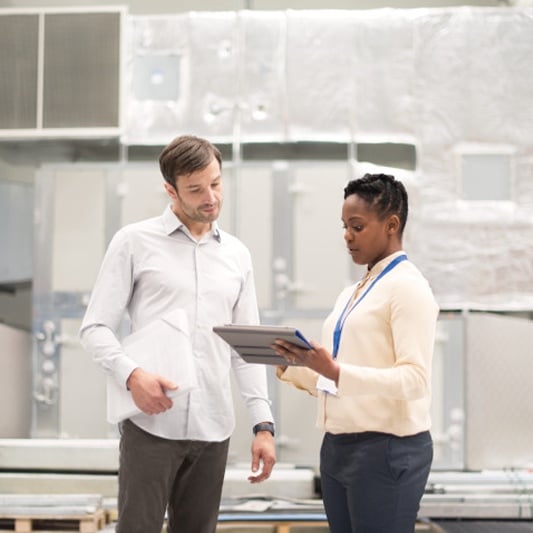 Two professionals discussing with a digital tablet.