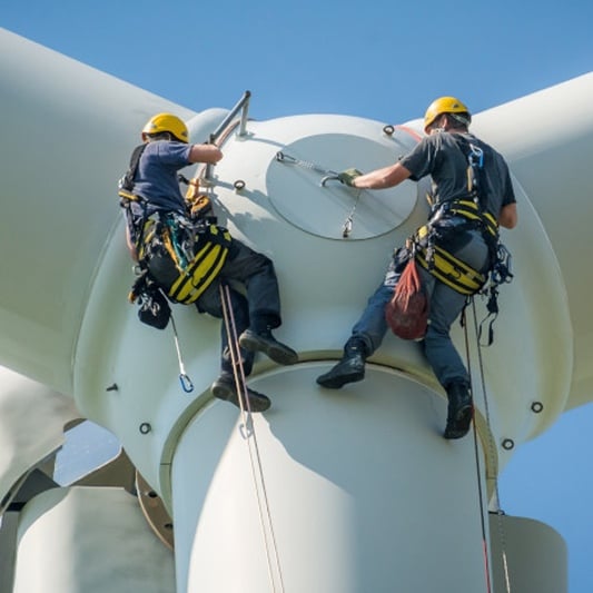 Technicians performing maintenance on wind turbine.