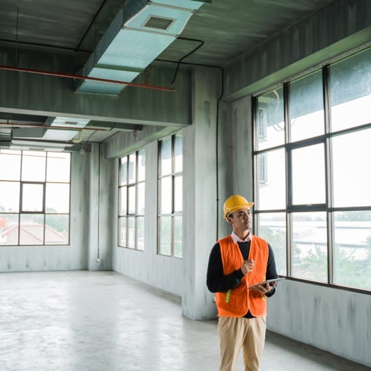 Engineer inspecting empty industrial building.