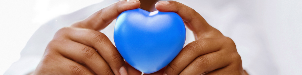 Blue plastic heart in hands