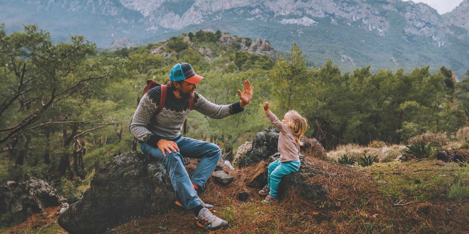 Father and child high five hands traveling in mountains hiking together