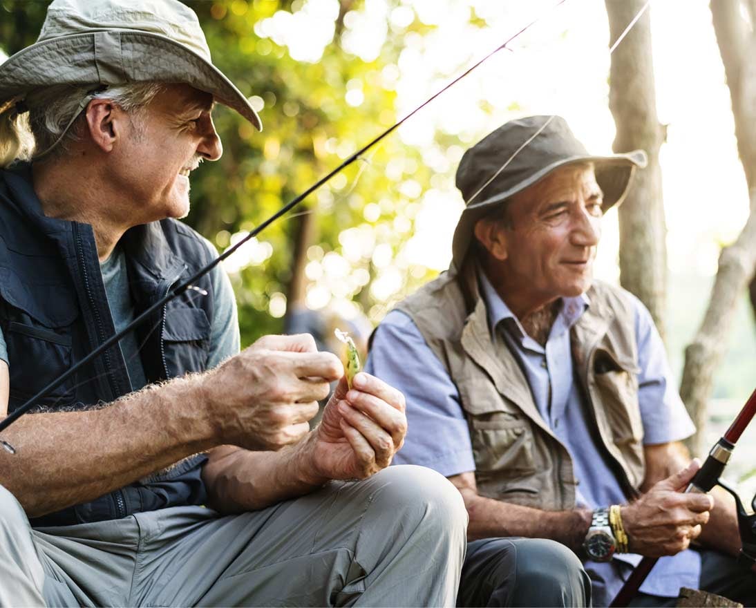 Senior friends fishing by the lake