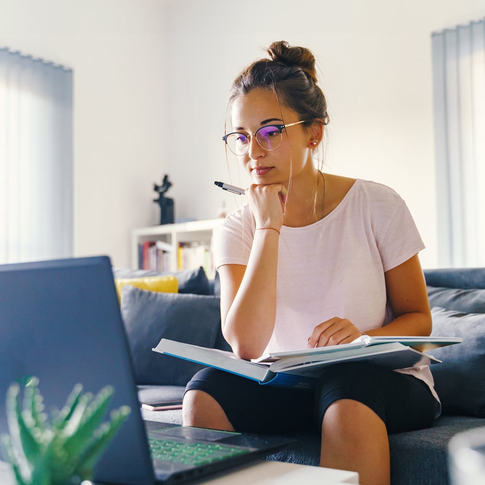 Woman studying with laptop and notebook