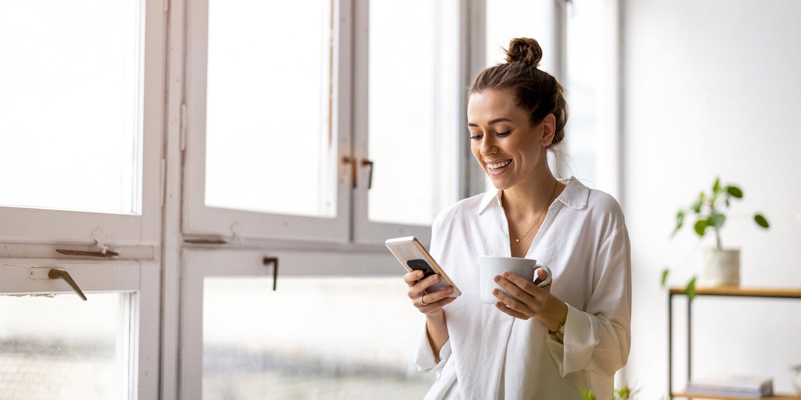 Creative business woman using smartphone in loft office
