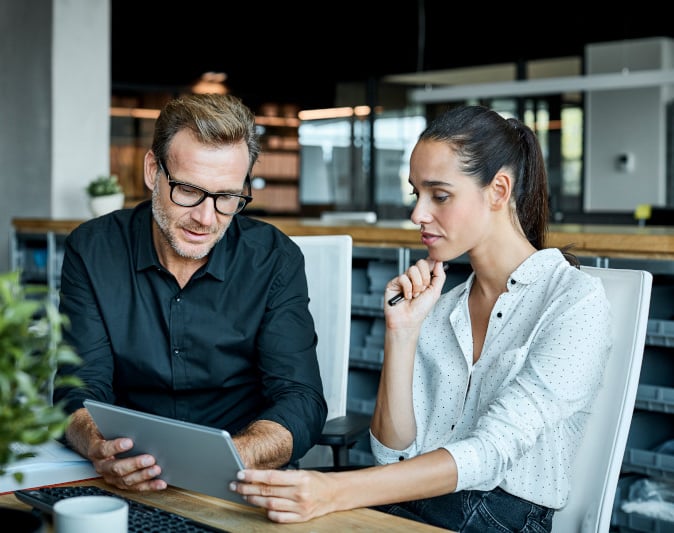 Male and female colleagues looking at tablet