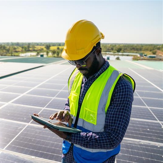 Risk engineer wearing protective equipment surveying a solar farm in the UK