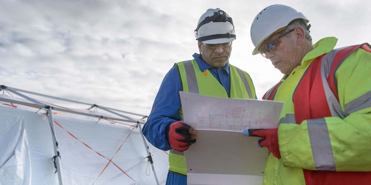 Two workers looking at blueprint