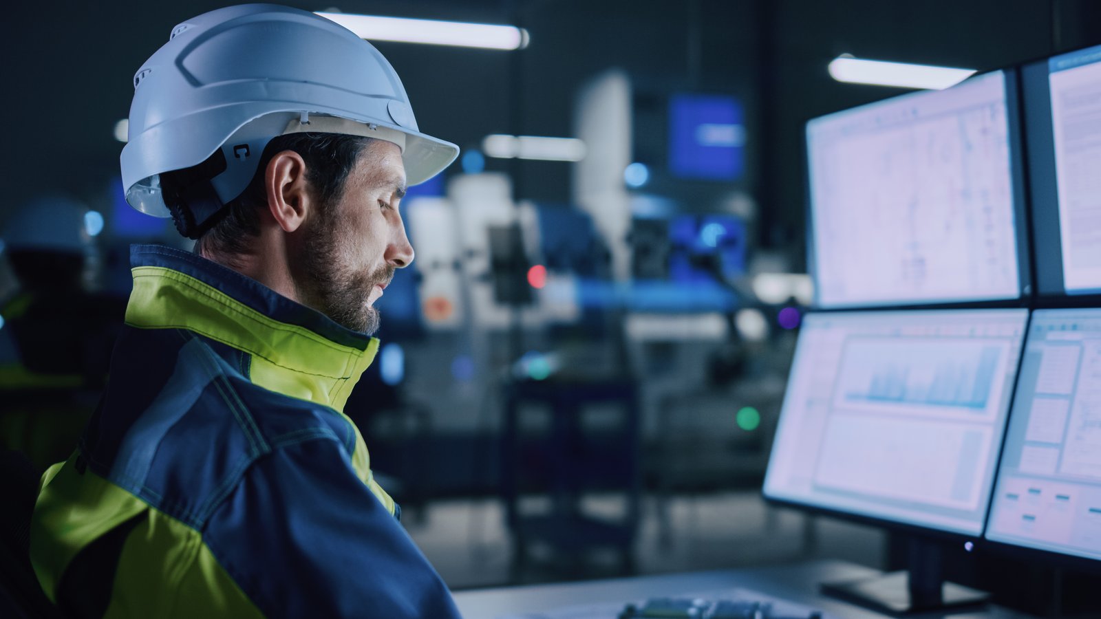Man at a computer with hard hat