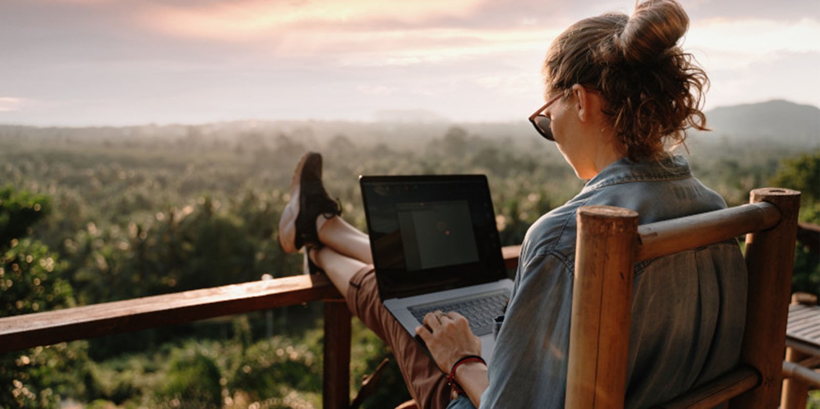 Eine Dame sitz im Urlaub am Laptop und  schließt eine Versicherungab