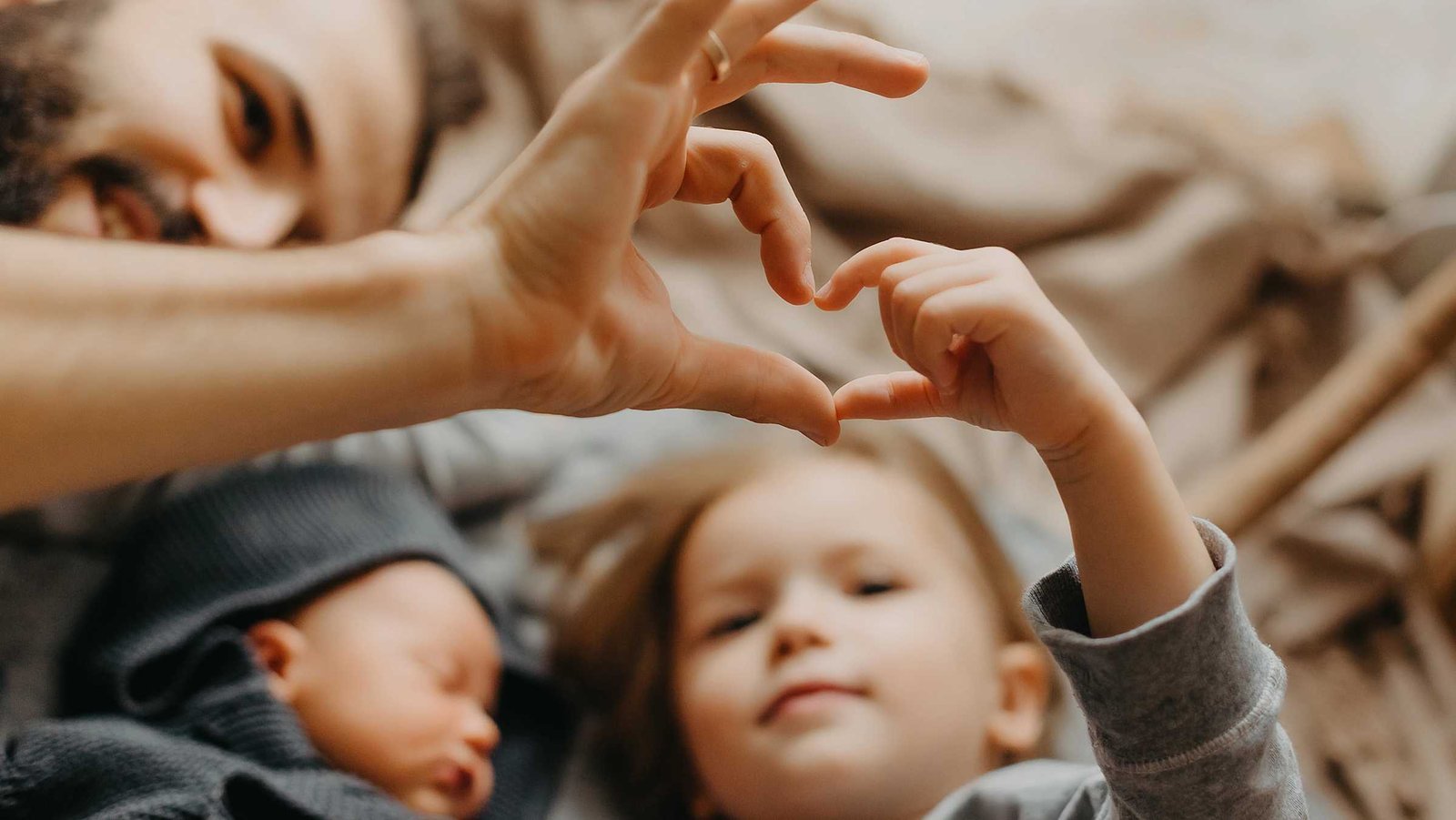 Vater und Sohn formen mit den Händen ein Herz