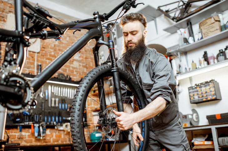 Mann in Werkstätte überprüft Fahrrad