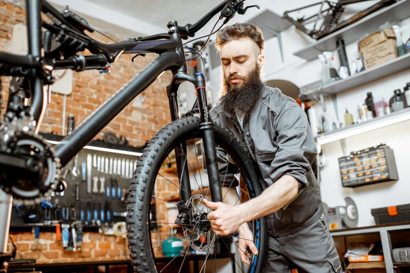 Mann in Werkstätte überprüft Fahrrad