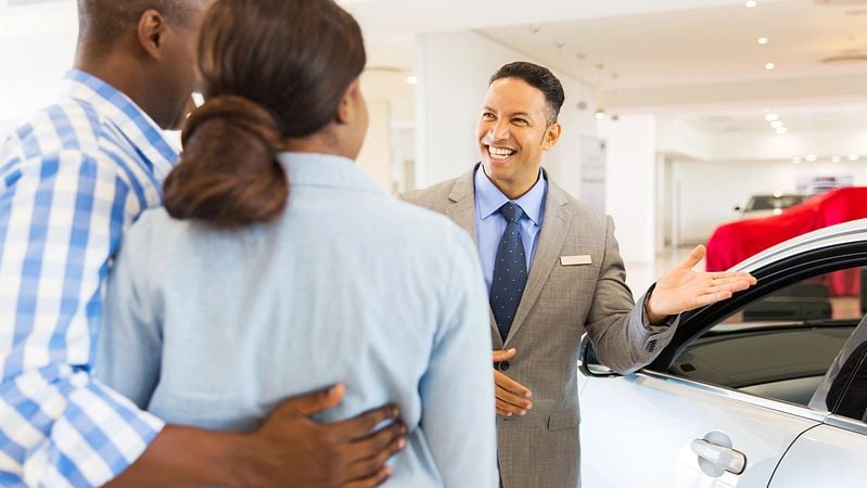 Der Verkäufer lädt das Paar zu einer Probefahrt ein.