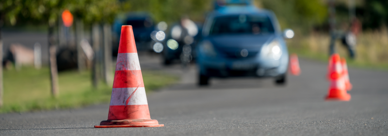 Auto fährt auf Straße, die tw. abgesperrt ist