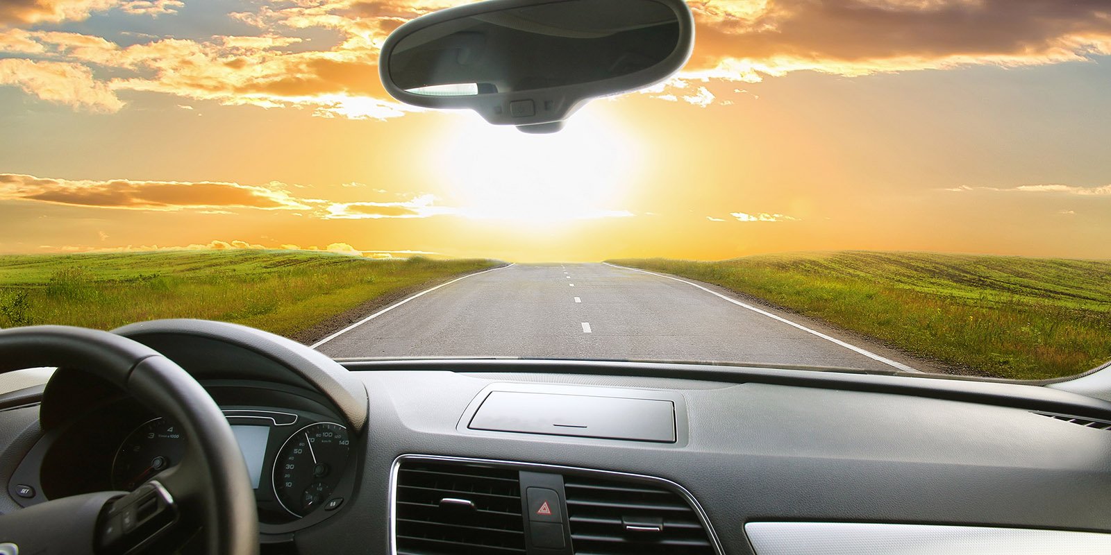 Auto fährt Richtung eines wunderschönen Sonnenuntergangs