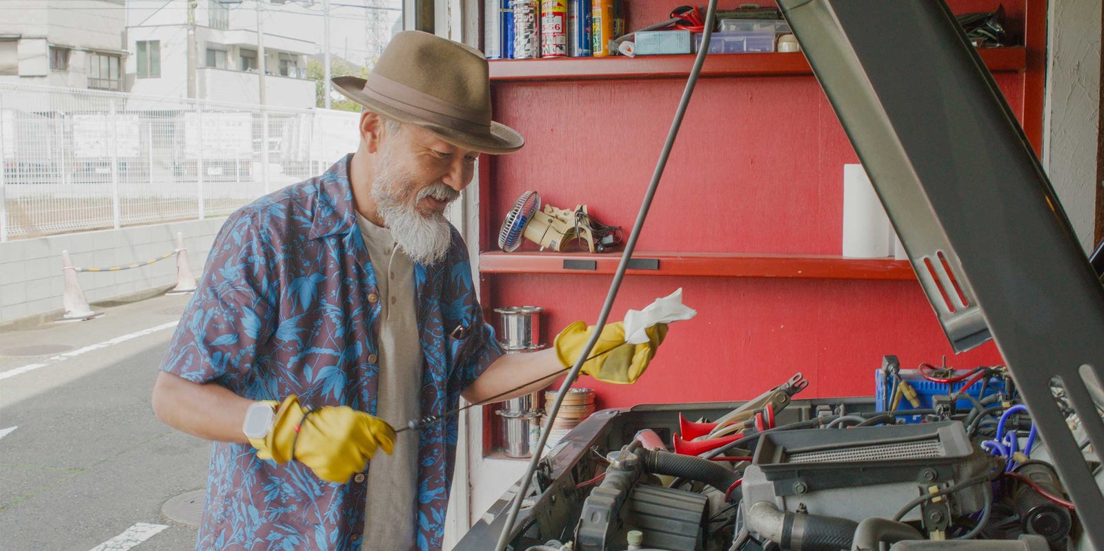 Ein Mechaniker kontrolliert den Motorraum eins Autos