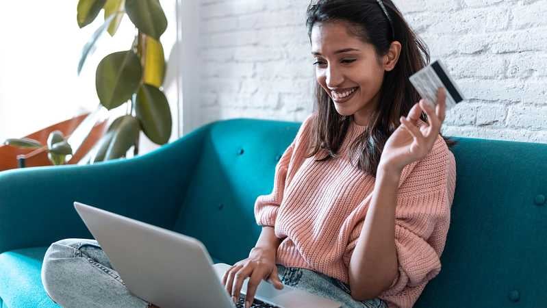 Dame sitzt vor dem Laptop und kauft online auf einer Gebrauchtwarenbörse ein.