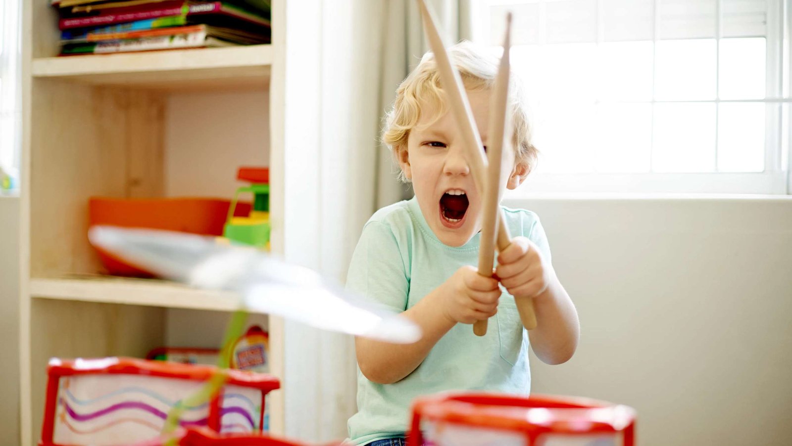 Ein kleines Kind trommelt motiviert am Schlagzeug