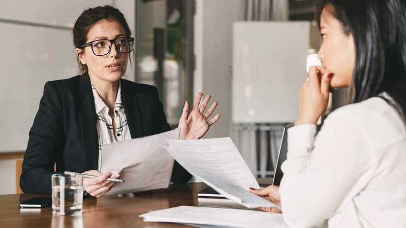 Eine Versicherungsberaterin erklärt einer Kundin wie die Lebensversicherung als Absicherung für einen Kredit verwendet werden kann.