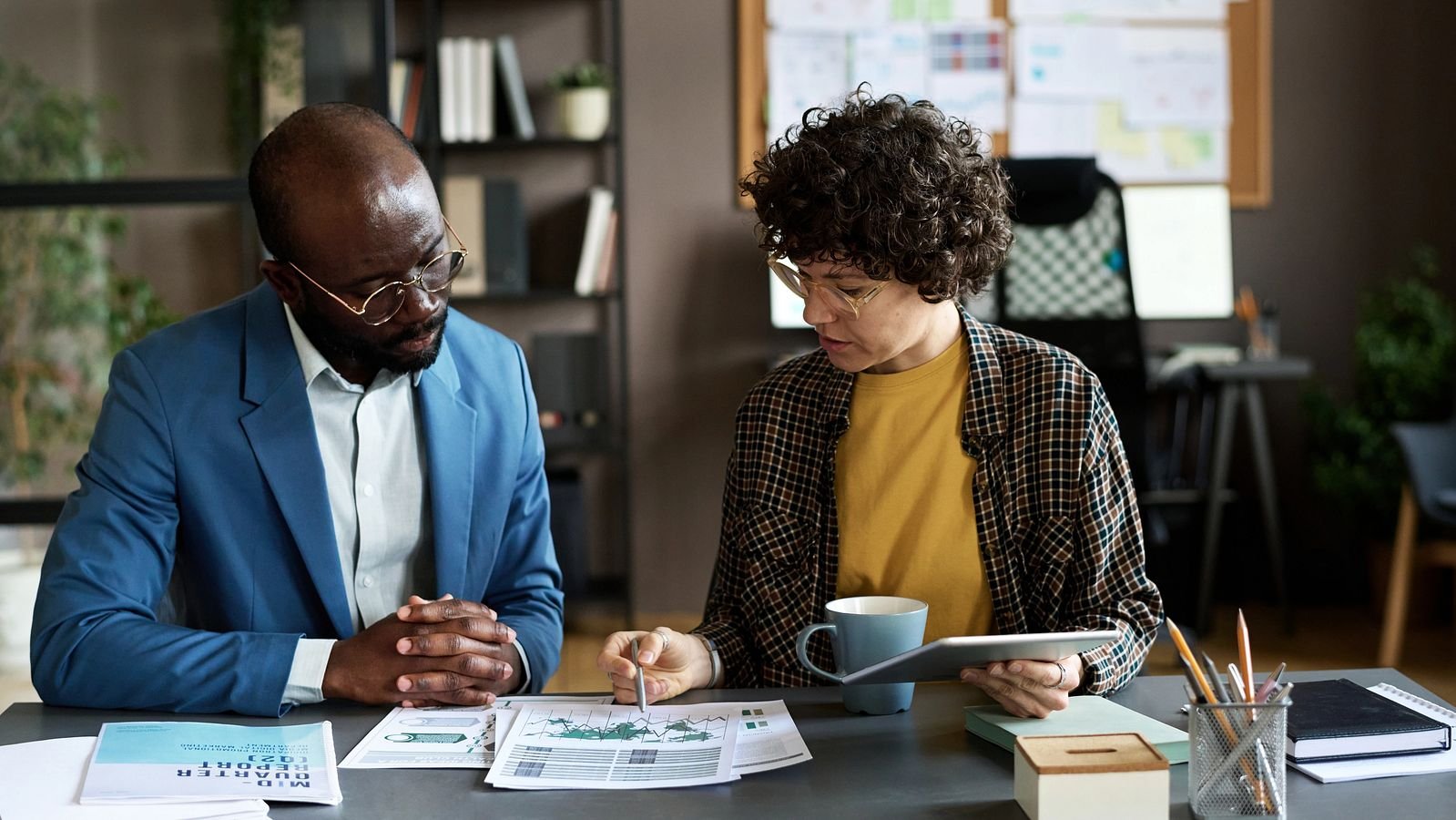 Ein Mann und eine Frau sehen sich die prognostizierten Zinsen für ihren Kredit an.,