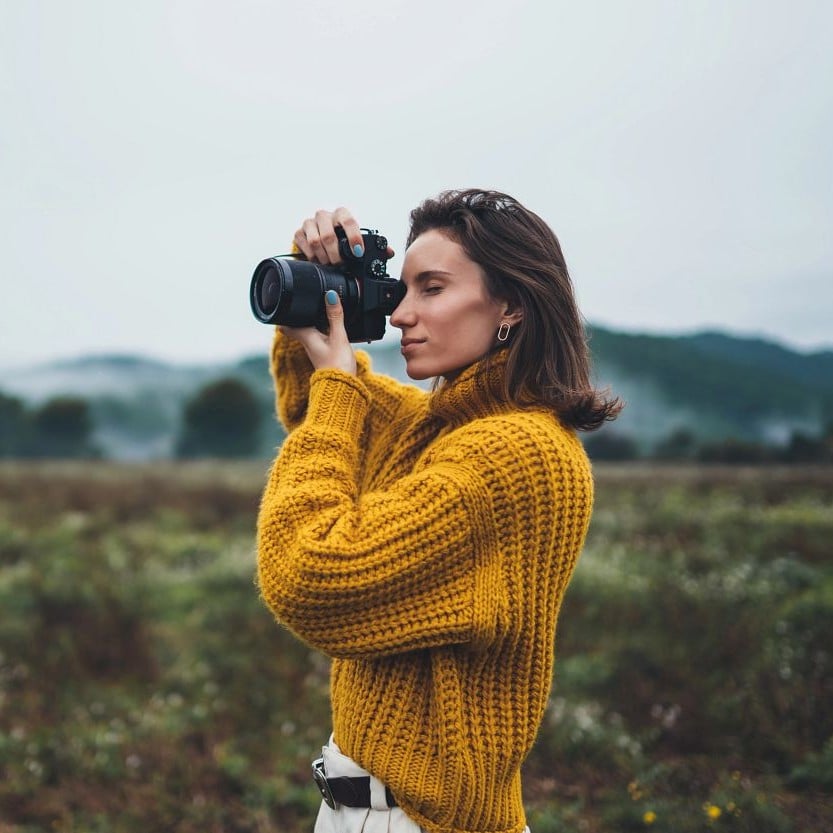 Frau fotografiert mit hochwertiger Spiegelreflexkamera
