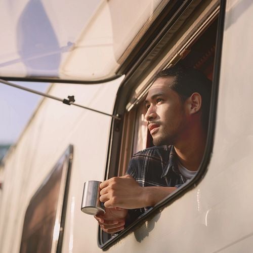 Mann blickt entspannt aus seinem Wohnmobil