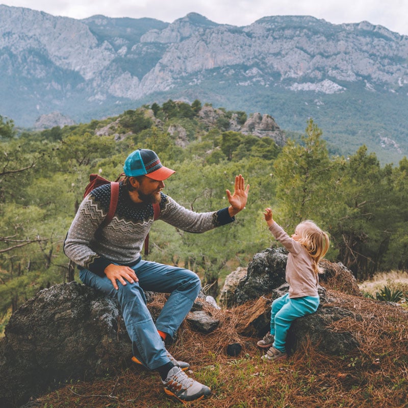 Vater und Tochter machen Pause beim Wandern in den Bergen
