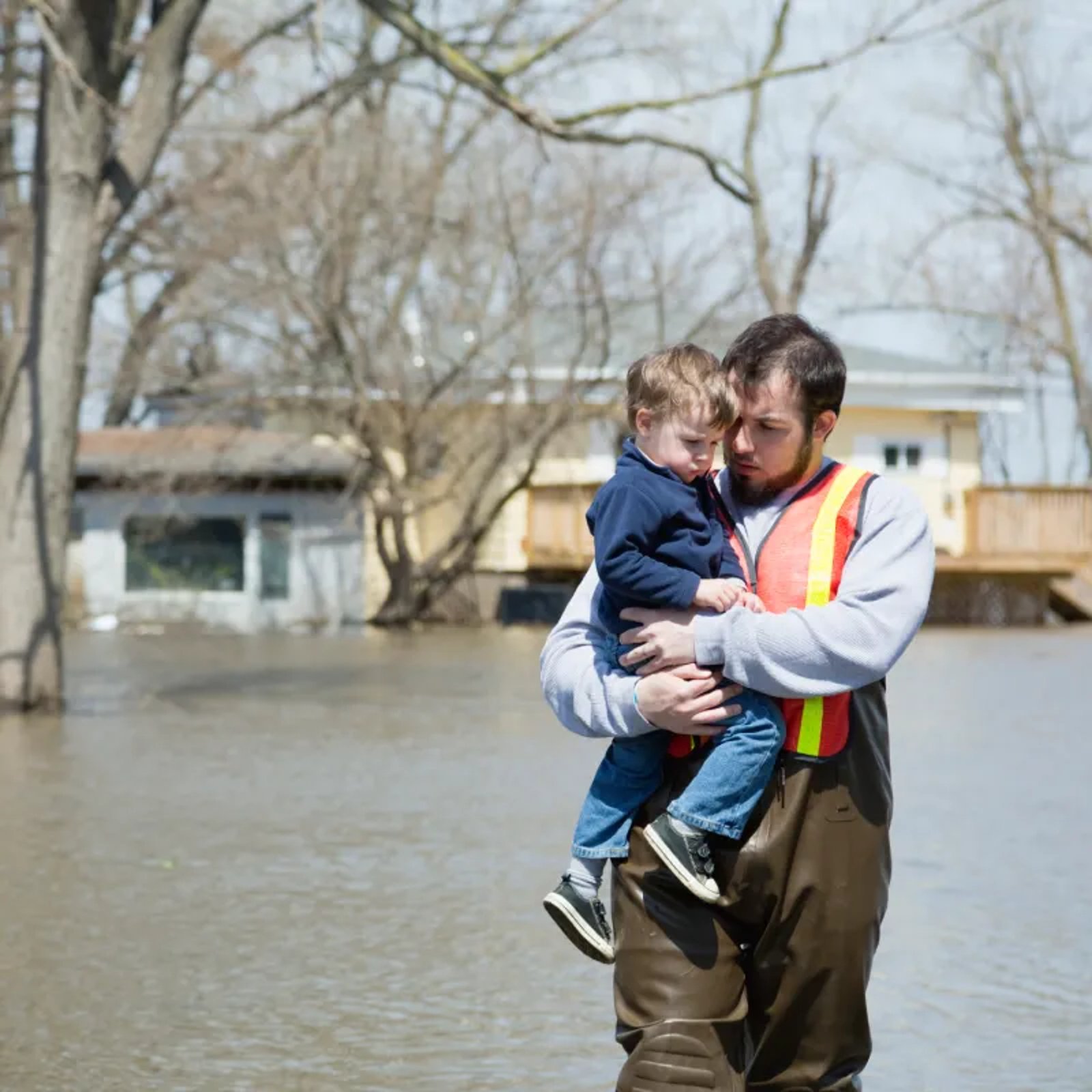 USA, Illinois, Man with son wading in floodwaters