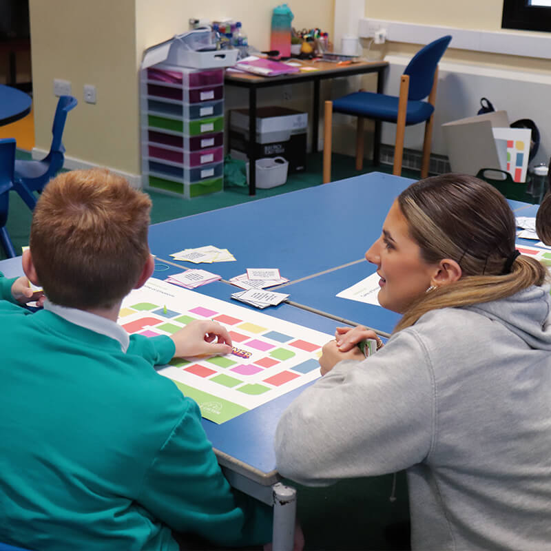 boy and woman sitting in a classroom